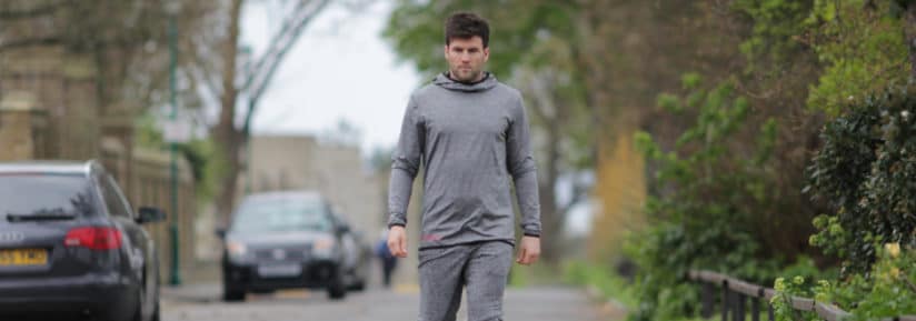 Homme en tenue de sport grise dans une rue
